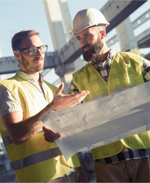 Deux ingénieurs discutent d'un ensemble de plans dans l'industrie de l'énergie.